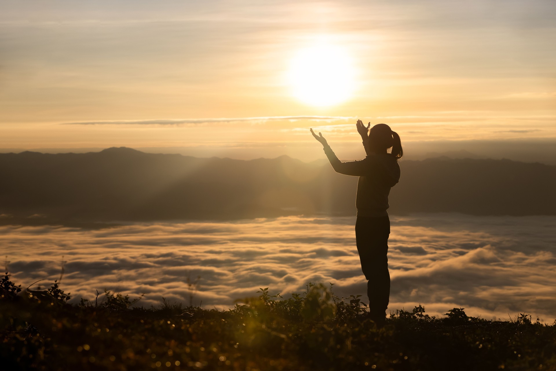 Silhouette of The girl  prayed  in the mountains to think of a loving God, we praise God.